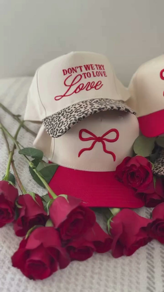 Video of adult cream and red hat with Red Puff Bow Embroidery on front, shown on flat lay – Little Mama Shirt Shop