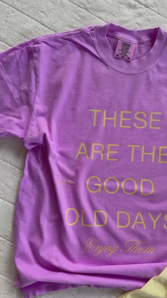 Video of adult CC Tee in butter and purple with 'these are the good old days'  printed on the front, seen on flat lay - Little Mama Shirt Shop