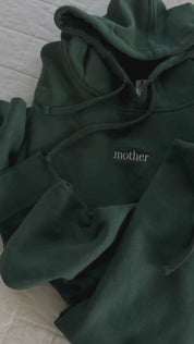 Video of adult alpine hoodie with mama or mother embroidered on the chest, seen on flat lay - Little Mama Shirt Shop
