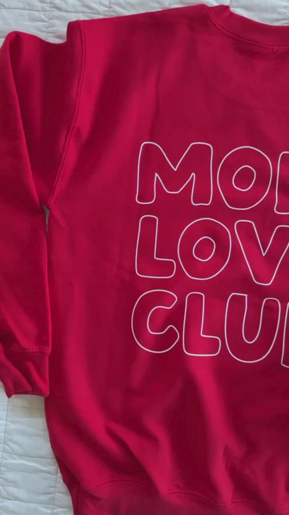 Video of adult sweater in red with "Mom Love Club" bubble letter text design on back and front left chest small, shown on flat lay – Little Mama Shirt Shop