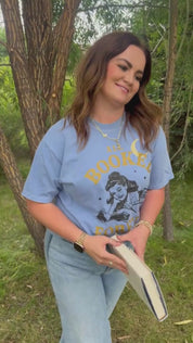 Video showing comfort colors tee in washed denim with 'All Booked Forever' graphic on model – Little Mama Shirt Shop