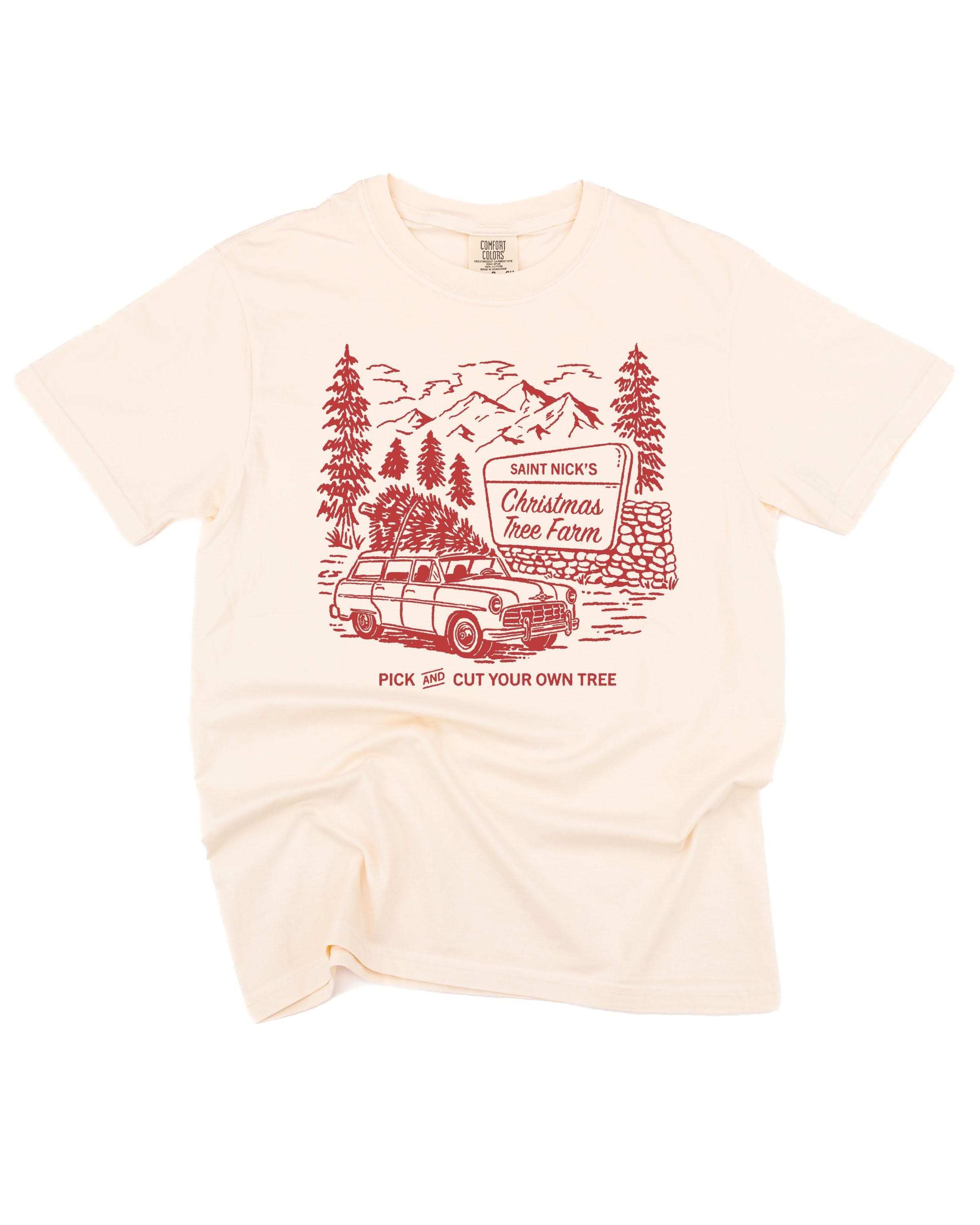 Comfort Colors Tee in ivory with St. Nick's Christmas Tree Farm graphic on the front, shown on flat lay – Little Mama Shirt Shop