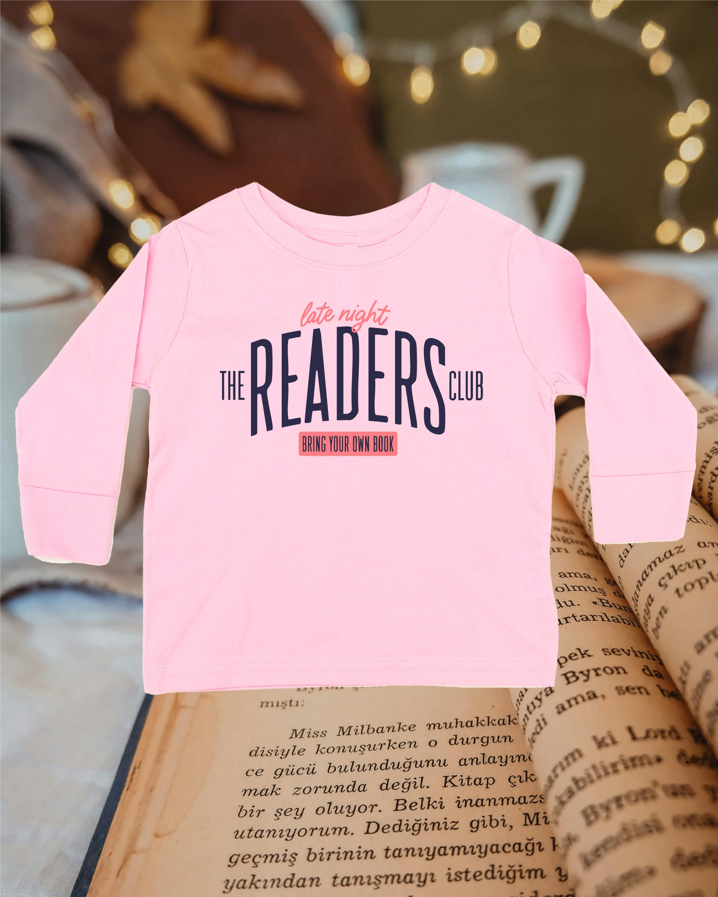 Child’s long sleeve tee with “Late Night Readers Club BYOB” design in pink, flat lay – Little Mama Shirt Shop