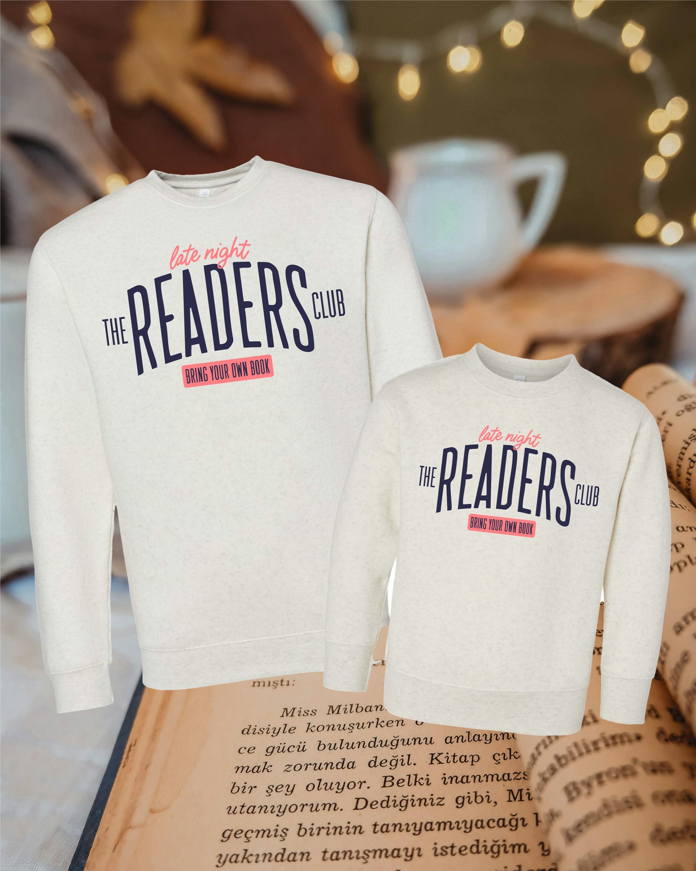 Coordinating natural heather mommy & me fleece sweaters with “Late Night Readers Club BYOB” design on flat lay – Little Mama Shirt Shop